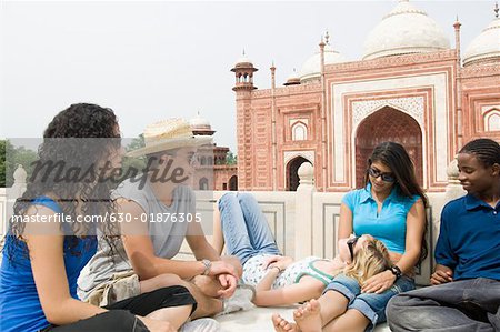 Zwei junge Männer sitzen mit drei jungen Frauen, Taj Mahal, Agra, Uttar Pradesh, Indien