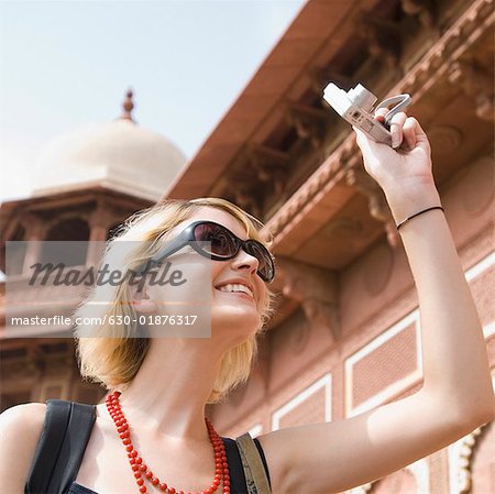 Gros plan d'une jeune femme de prendre une photo avec un appareil photo numérique, Taj Mahal, Agra, Uttar Pradesh, Inde