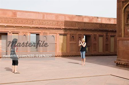 Junge Frau, die ein Bild von ihrem Freund, Taj Mahal, Agra, Uttar Pradesh, Indien