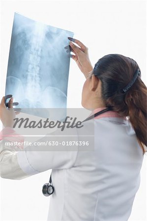 Rear view of a female doctor examining an X-Ray image