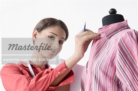 Portrait d'un créateur de mode féminin une chemise sur un mannequin de réglage