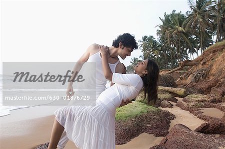 Young couple romancing on the beach, Goa, India