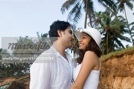 Profil de côté d'un jeune couple romancing et souriant sur la plage, Goa, Inde