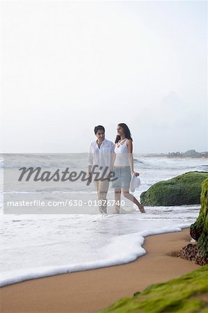 Young couple walking together on the beach