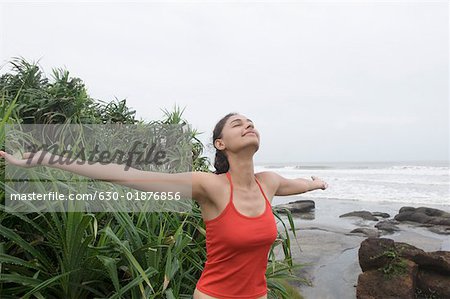 Junge Frau am Strand mit ihrem ausgestreckten