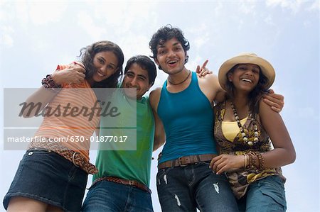 Low angle view of two young couples standing together and smiling