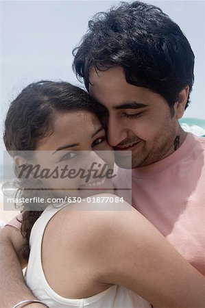 Close-up of a young couple embracing each other and smiling