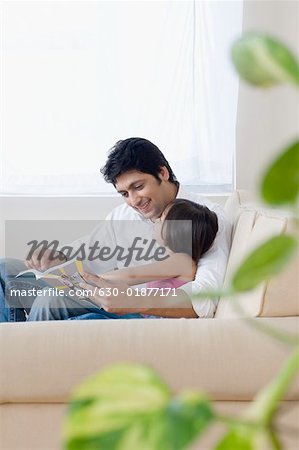 Milieu adulte homme lisant un livre avec sa fille