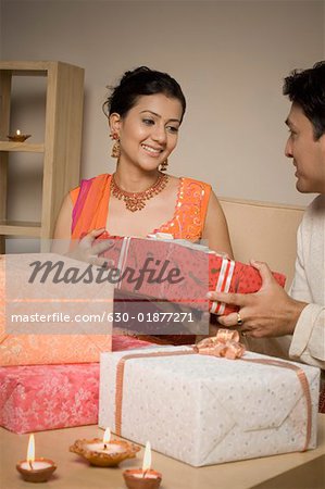 Young man giving a diwali gift to a young woman