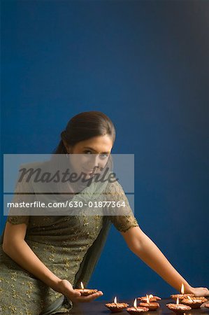 Portrait d'une jeune femme tenant une lampe à huile et souriant