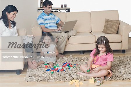 Mitte adult Couple mit ihren beiden Töchtern in einem Wohnzimmer