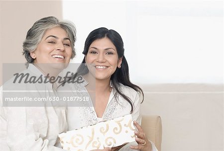Porträt einer Frau mittleren Alters die ein Geschenk für ihre Mutter und Lächeln