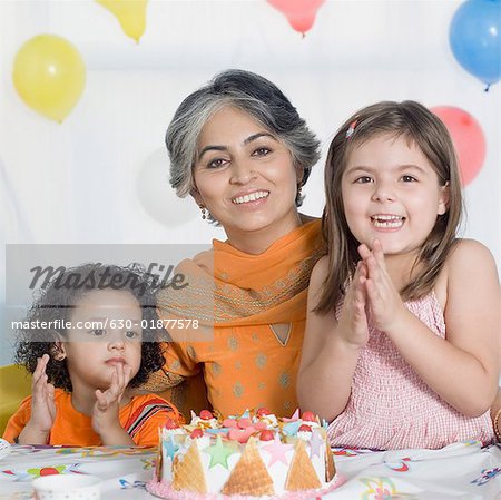 Portrait of a mature woman celebrating her birthday with her two granddaughters