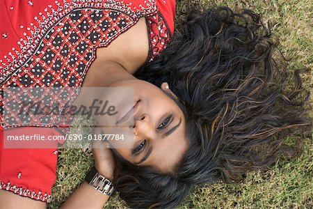 Portrait of a young woman lying on the grass