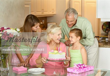 Mädchen feiert Geburtstag mit Schwester und Großeltern