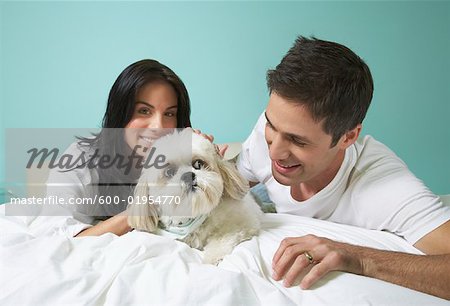 Couple with Dog on Bed