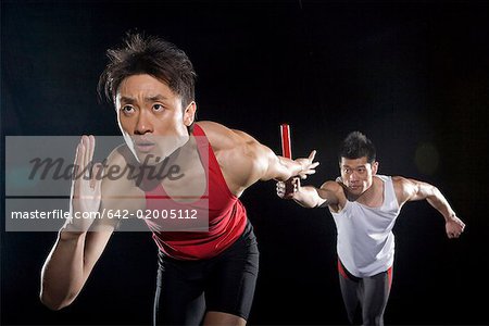 deux hommes en compétition dans la course à relais de sport