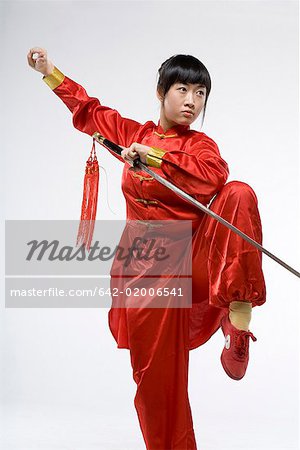 eine Frau im roten Kleid chinesische Kungfu mit einem Schwert üben