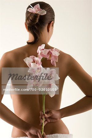 Frau hält Blumen hinter Rücken