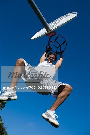Man Hanging from Basketball Net