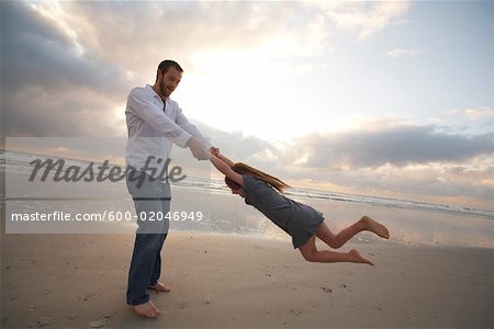 Vater und Tochter spielen am Strand