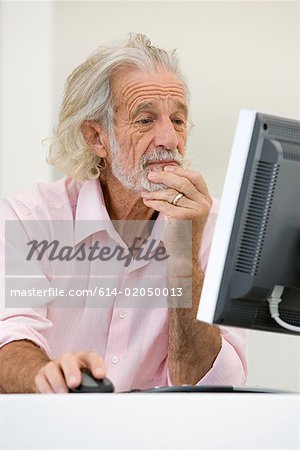 Homme senior à l'aide d'ordinateur