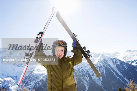 Boy holding skis above his head