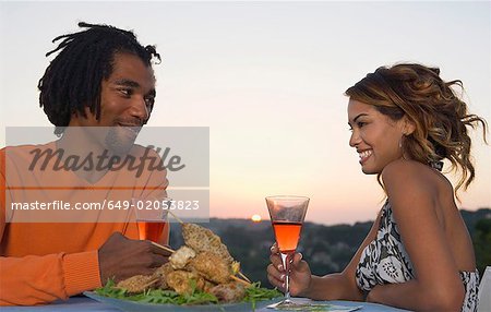 Homme et femme à un barbecue au coucher du soleil