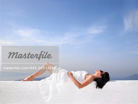 Woman resting on a white wall