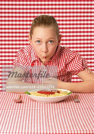 Fille (10-11 ans) manger des spaghettis