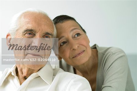 Senior couple together, smiling, looking away