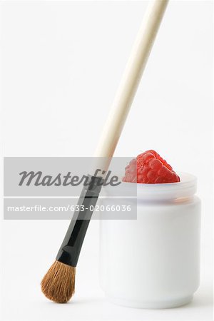 Make-up brush and raspberry in small container
