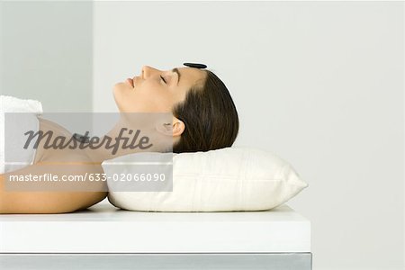 Woman receiving lastone therapy, eyes closed