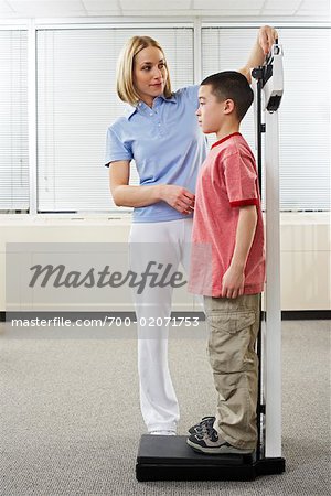 Physiotherapist Measuting Boy's Height