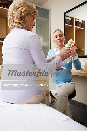 Physiotherapist Showing Woman Model of Spine