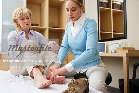 Physiotherapist Examining Woman's Foot