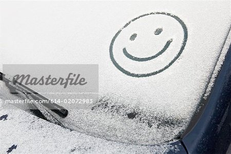 Smiley face en neige sur la voiture