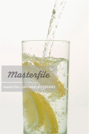Water Pouring into Glass with Lemons Water Pouring into Glass with Lemons