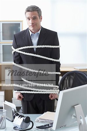 Businessman Tied Up with Rope at Desk