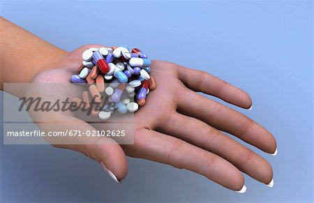 An open human palm holding a pile of pills.