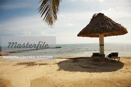 Beach Chairs under Beach Umbrella on Beach, Belize