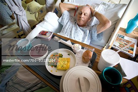 Man in Hospital Bed with Tray of Food in Front of Him