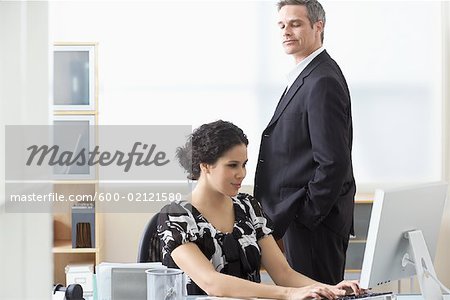 Businessman Looking over Businesswoman's Shoulder