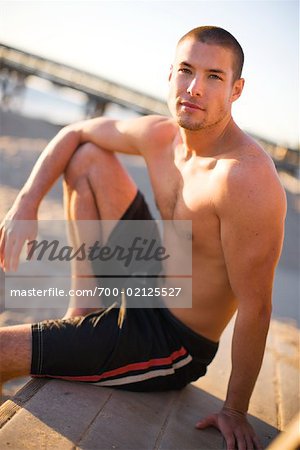 Man Sitting on Beach at Dusk