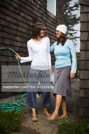 Deux femmes de lavage de sable large de pieds