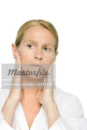 Mature woman touching face, looking away