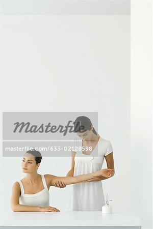 Woman receiving arm massage, looking away