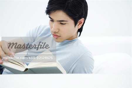 Young man reading book, turning page