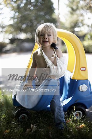 Boy with Broken Arm Playing in Toy Car
