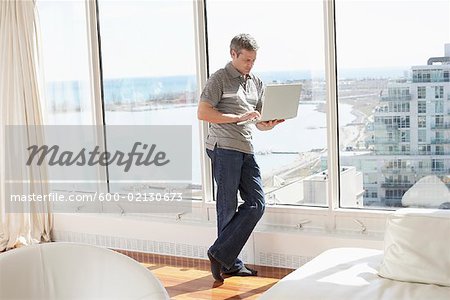 Homme avec ordinateur portable en Condominium